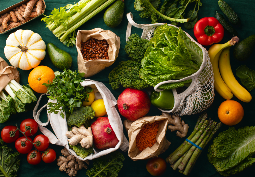 Frissen szállított, helyben termesztett gyümölcsök és zöldségek környezetbarát papírzacskókba vagy textil bevásárlótáskákba csomagolva, hulladékmentes vegetáriánus táplálkozási koncepció.