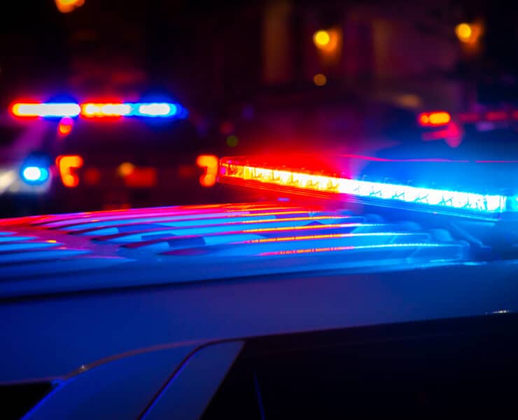 Piros és kék rendőrségi fények egy éjszakai helyszínen, illusztráció.