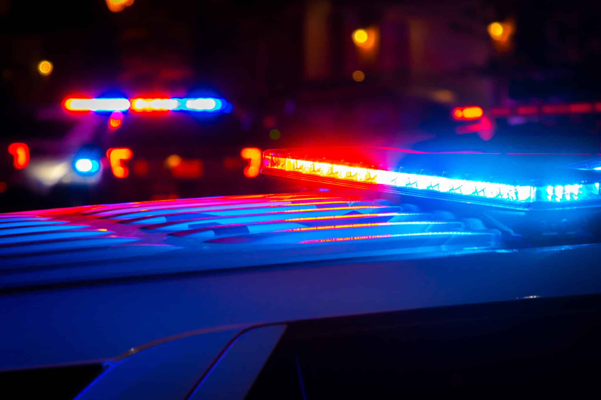 Piros és kék rendőrségi fények egy éjszakai helyszínen, illusztráció.