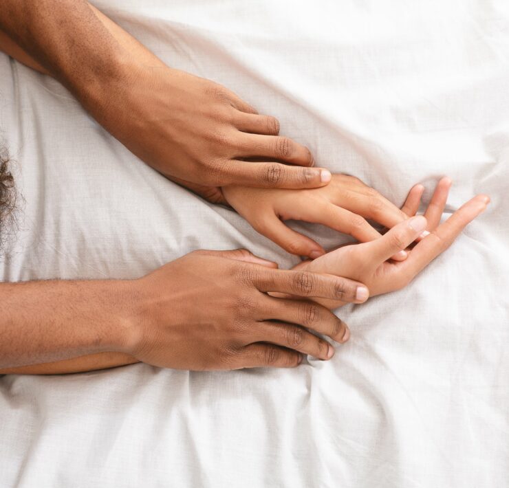 Férfi és női kezek az ágyban, szexuális életet szimbolizálva
