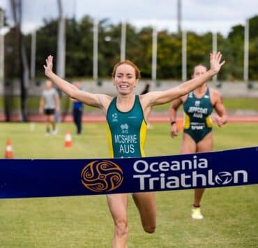 Charlotte McShane vegán triatlonista átszakítja a szalagot első helyezettként az Óceánia Triatlonon.