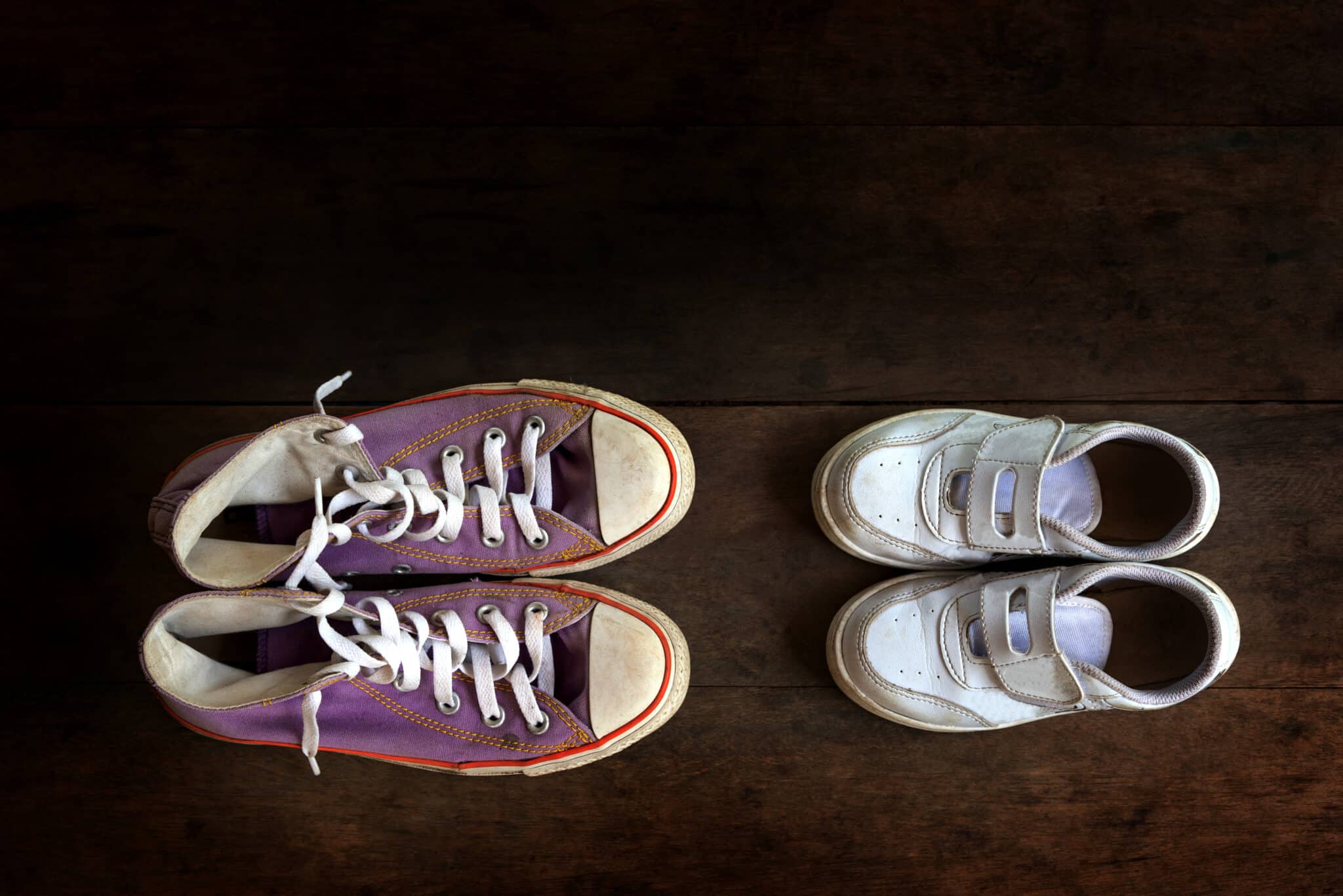 Bal oldalt lila színű, felnőtt tornacipő, jobb oldalt krémszínű gyerekcipő