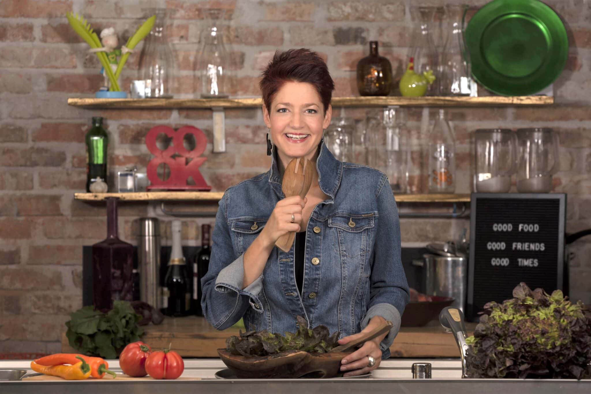 Vágó Piros műsorvezető fakanalat tart a szája elé, mintha mikrofon lenne.