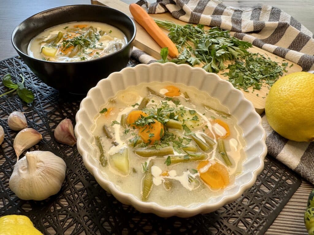 Két tányér nyári zöldbableves, mellette fokhagyma, répa, citrom