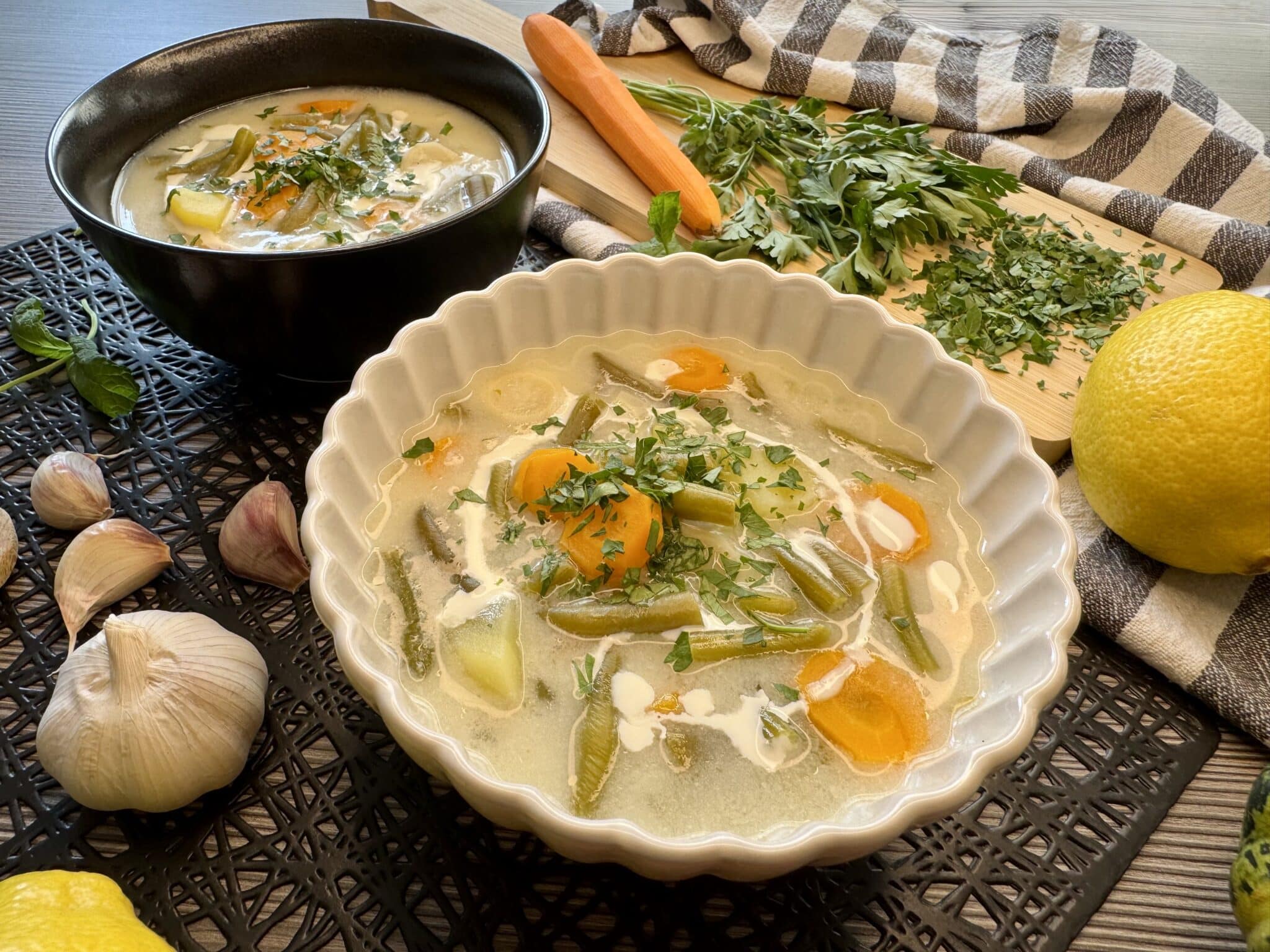 Két tányér nyári zöldbableves, mellette fokhagyma, répa, citrom