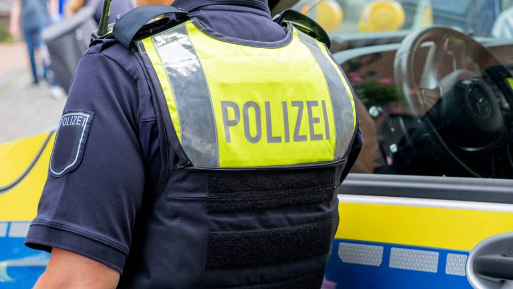 Rendőr áll háttal, a hátán POLIZEI felirat