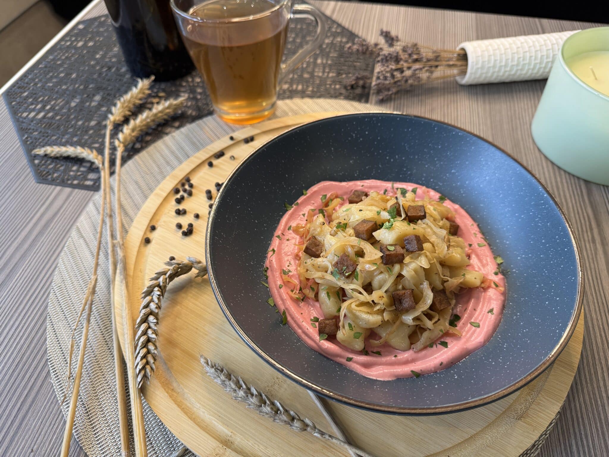 Káposztás gnocchi kék tányérban, céklakrémmel körülvéve, rajta pirított tofukockák