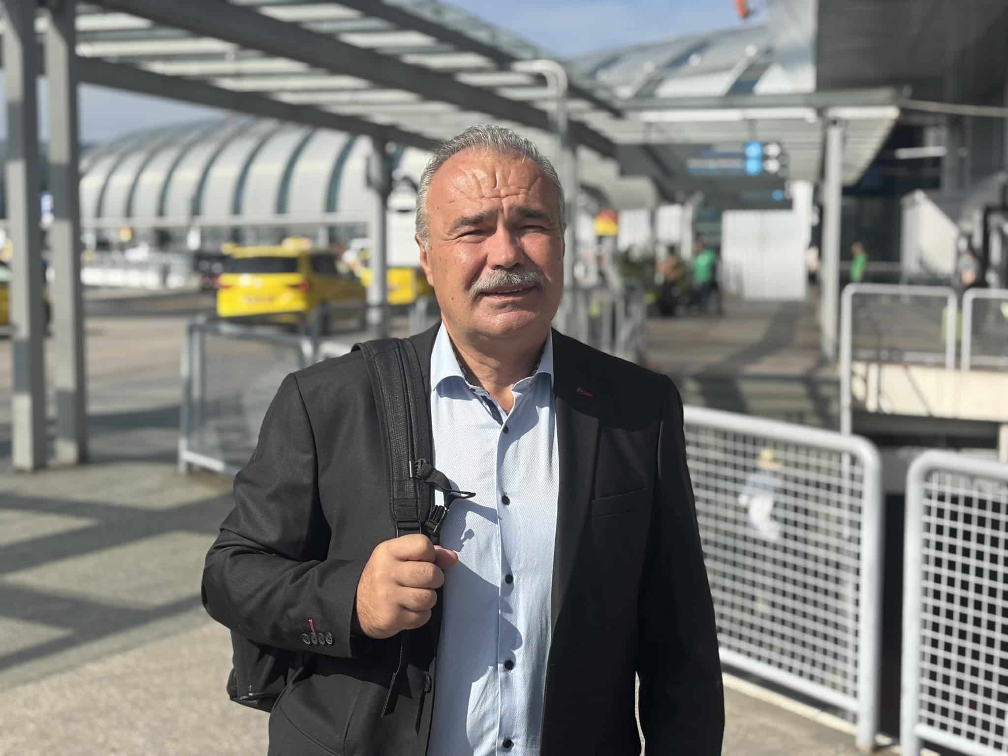 Nagy István repülőtéren, félvállra vetett táskával