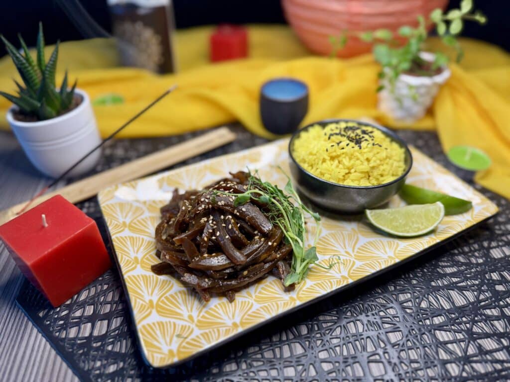 Wokban szószókkal barnára sült dinnyehéj szezámmaggal, mellette kurkumás rizs, ázsiai hangulatú tányér