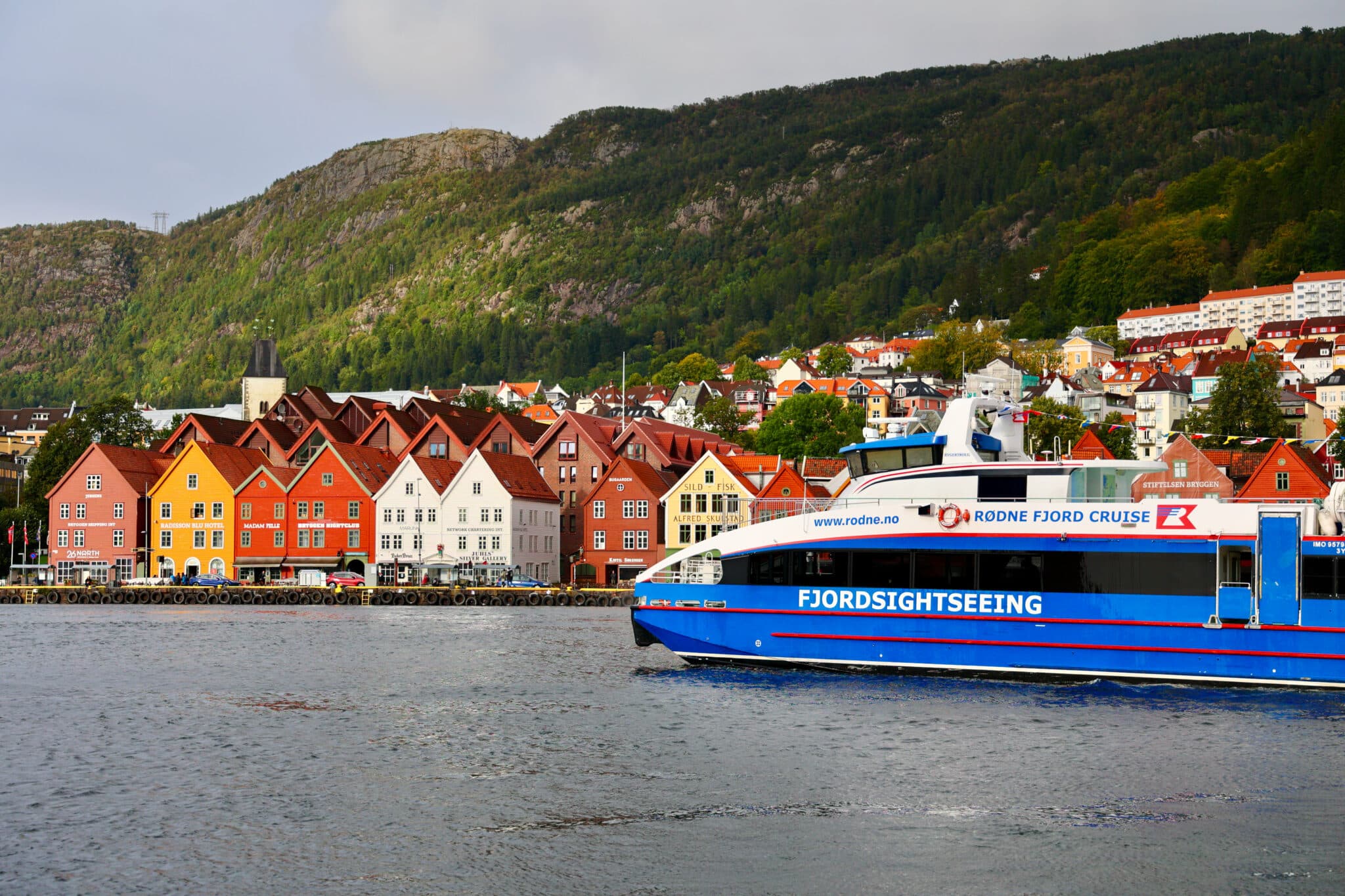 Skandináv városi látkép, előtte pedig hajó siklik a vizen
