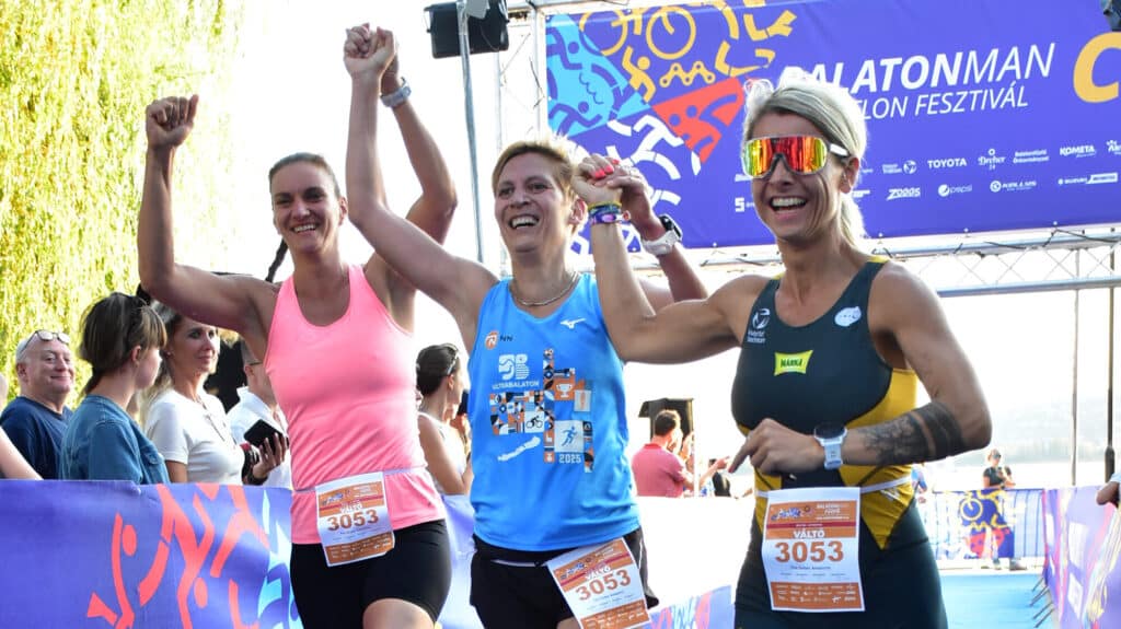 Három női futó együtt, kéz a kézben ér be a Maratonman céljába