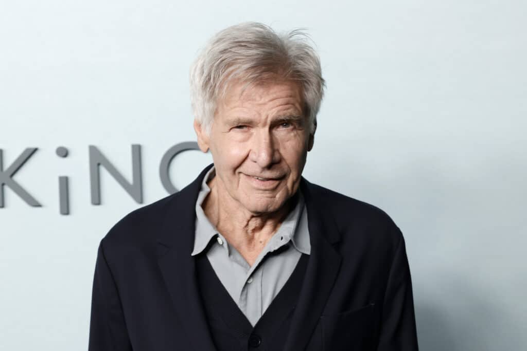 Harrison Ford szürke ing felett fekete pulcsiban mosolyog a kamerába