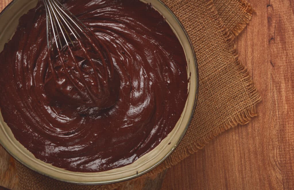 Mogyorókrém egy barna tálban, benne habverő