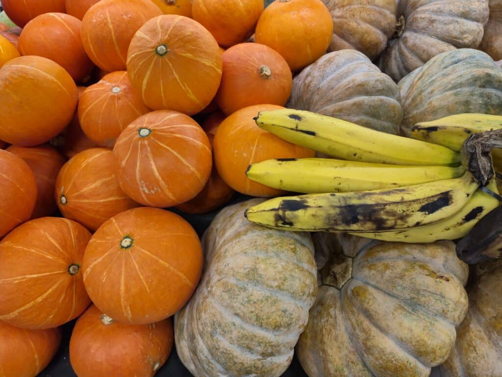 Narancssáfra és sárga sütőtökök, rajtuk banánok